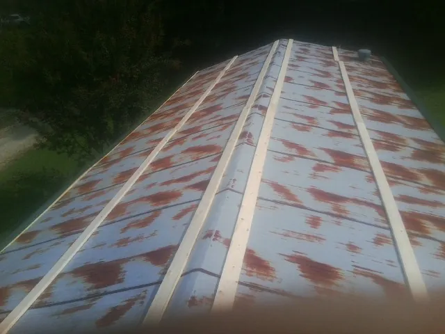 Rusted metal roof panels with new wood purlins before replacement — Storm Damage Roof Repair in Santa Rosa Beach by Roofing Brothers