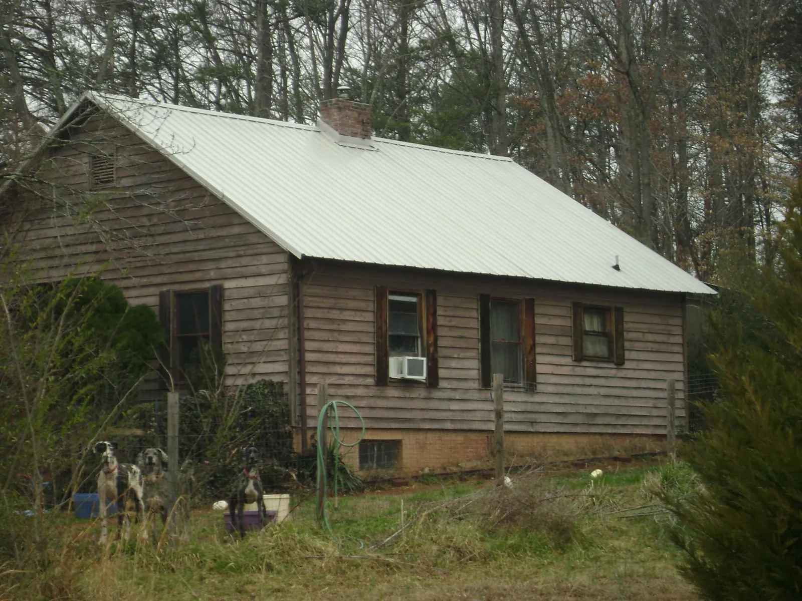 White metal roof on an old wood sided farmhouse, from a Metal Roof Installation job in Santa Rosa Beach